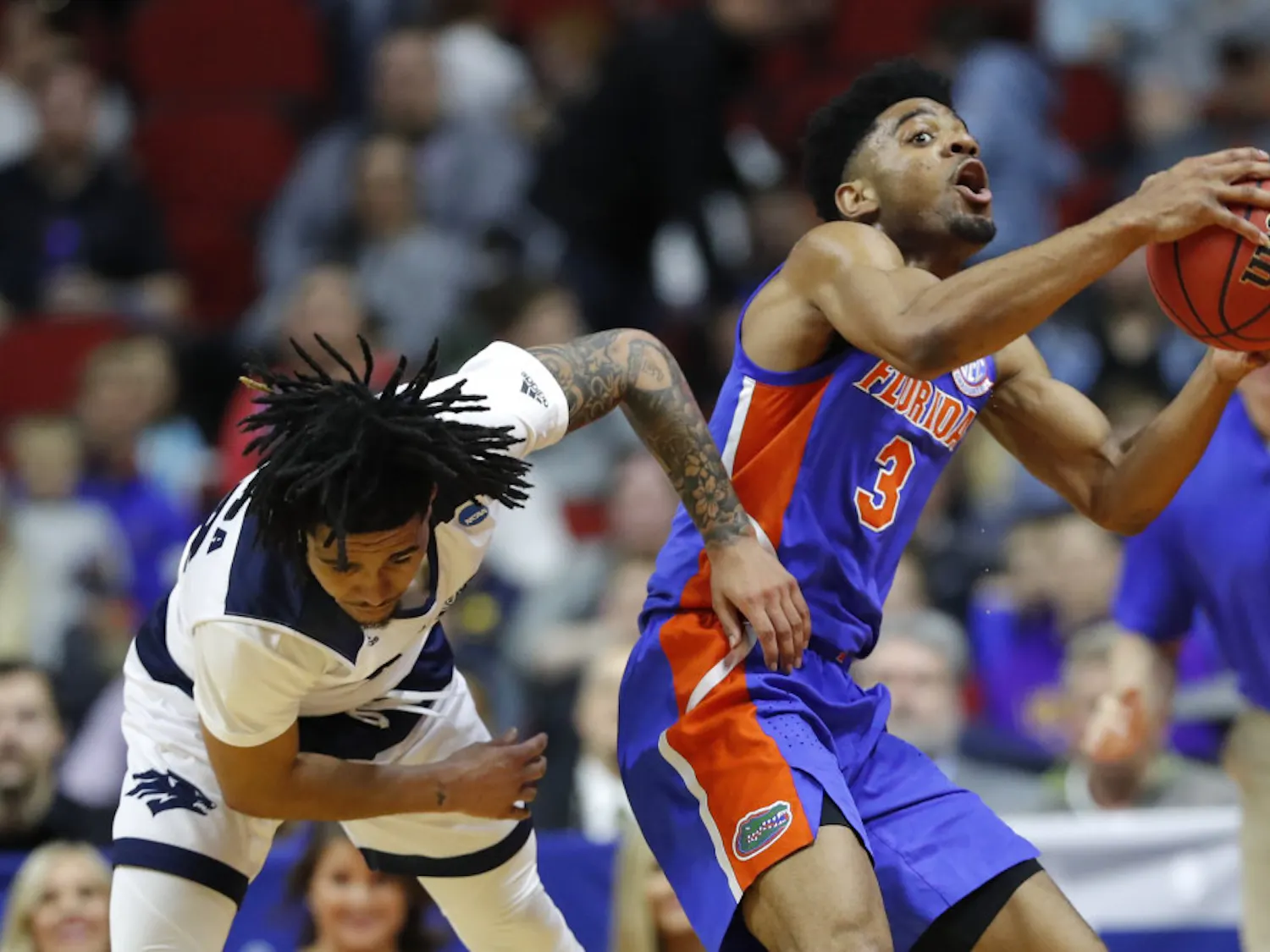 Florida guard Jalen Hudson (right) grabs a loose ball over Nevada guard Jazz Johnson during the Gators’ 70-61 win in the First Round in the NCAA Tournament on Thursday in Des Moines, Iowa.
