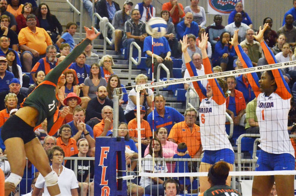 <p>Mackenzie Dagostino (6) and Rhamat Alhassan (1) attempt to block a kill attempt&nbsp;during No. 8 seed Florida's 3-1 win against Miami in the second round of the NCAA Tournament on Saturday in the O'Connell Center.</p>