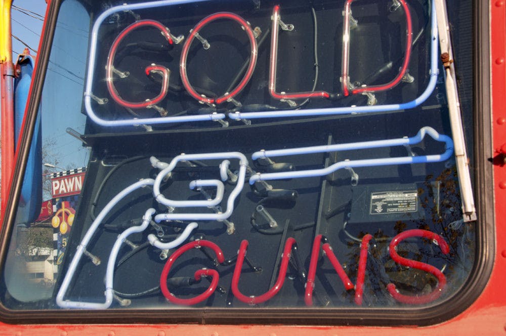A sign outside of Best Jewelry and Loan, on 523 NW 3rd Ave, advertises guns for sale. Violent crime in America is receding, but gun violence remains relatively stable. Someone under the age of 25 is killed from gunfire every 70 minutes, according to a report by the Center for American Progress.