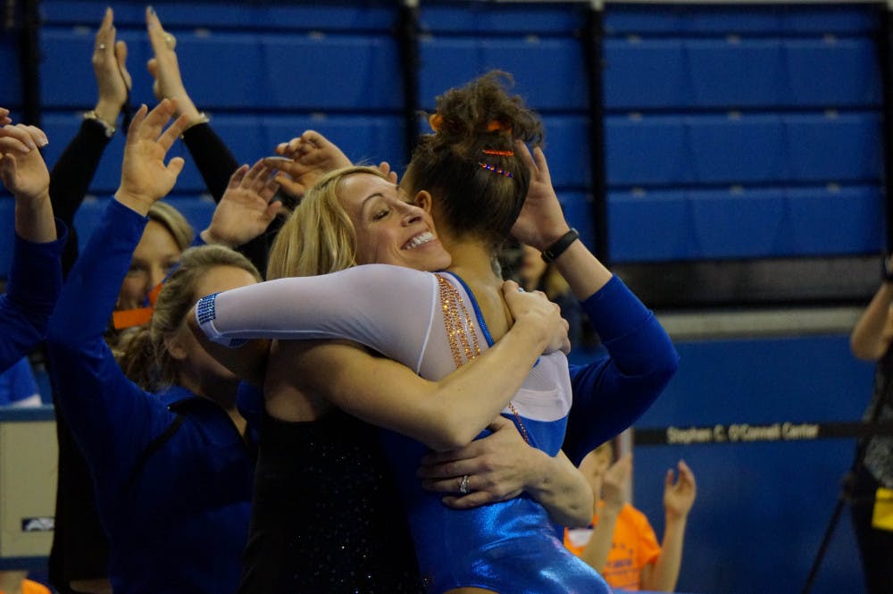 Coach Rhonda Faehn hugs Kytra Hunter following Hunter's balance beam routine during Florida's win against Missouri on Friday in the O'Connell Center.