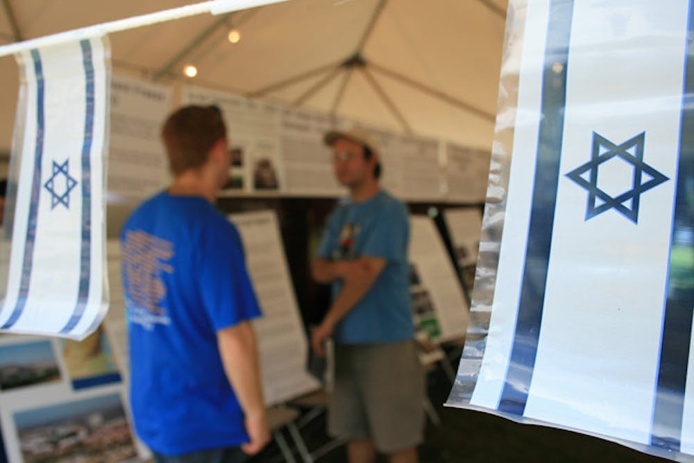 <p>Rick Rosenbluth, a third-year Jewish studies and family, youth, and community sciences major, and Oscar Gonzalez, an ecology graduate student, chat at "Talk Israel" on the Plaza of the Americas Wednesday.</p>