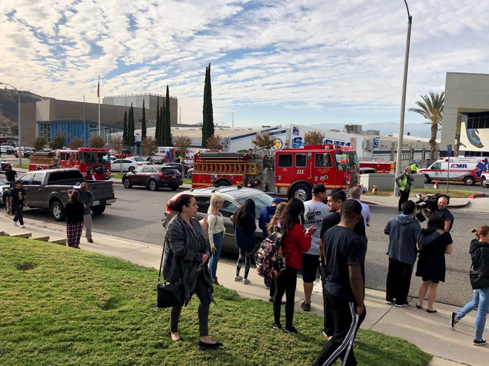 People wait for students and updates outside of Saugus High School after reports of a shooting on Thursday, Nov. 14, 2019, in Santa Clarita, Calif. (AP Photo/Marcio Jose Sanchez)