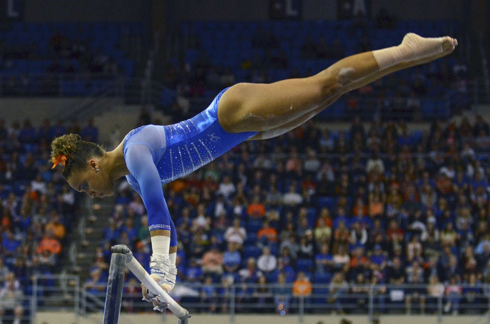 <p>Kytra Hunter performs on the uneven parallel bars during Florida's 197.60-196.950 win against Georgia on Friday in the O'Connell Center.</p>