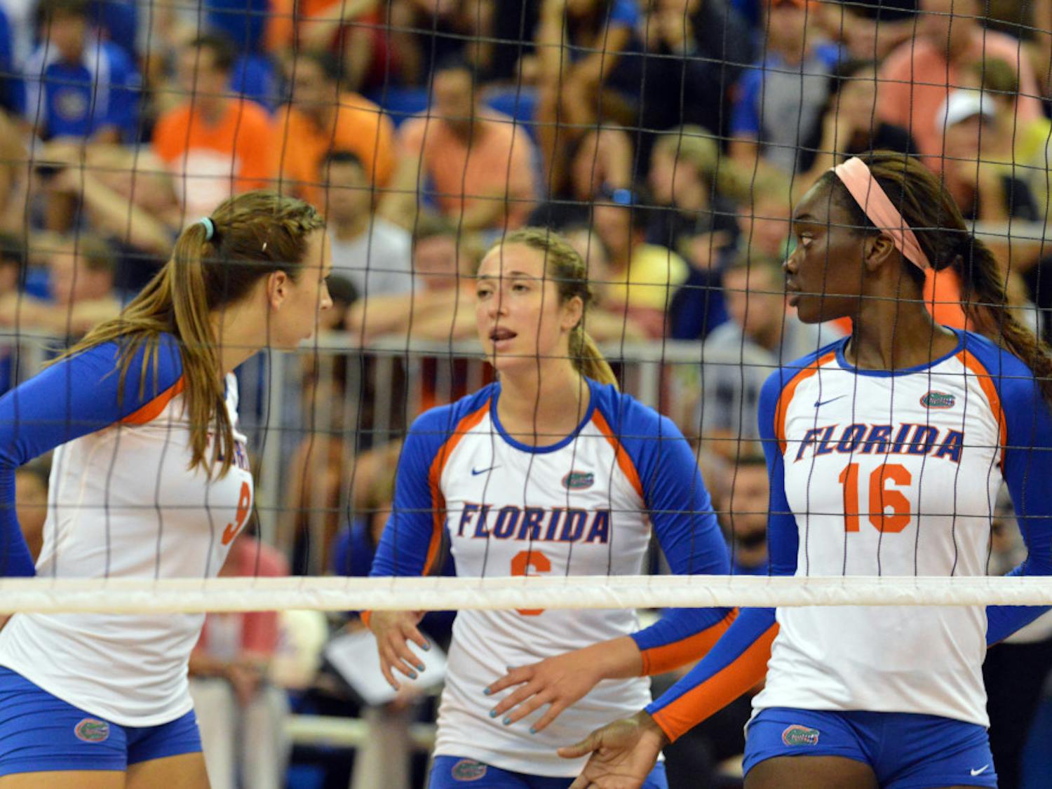 Setter Mackenzie Dagostino (center) talks to outside hitter Ziva Recek (left) and middle blocker Simone Antwi (right) before a play during Florida's 3-0 win against Idaho.
