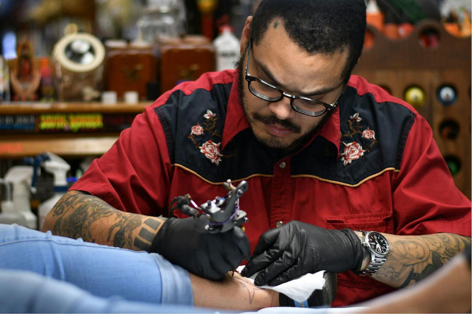 Jesus Lopez, a 30-year-old tattoo artist at Death or Glory, outlines a shark tattoo Saturday afternoon during Death or Glory’s tattoo benefit fundraiser. All money made from the event will go towards treatment for Nicole Hall’s breast cancer. Hall is a frequent customer at Death or Glory, and over 200 people attended the benefit.