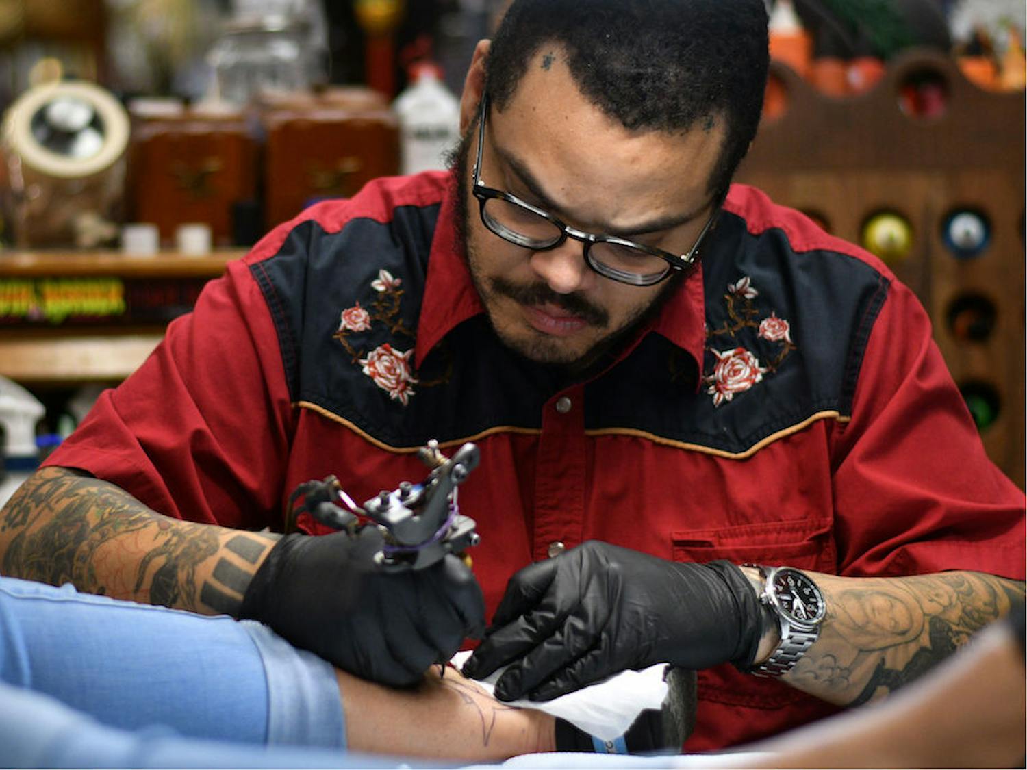 Jesus Lopez, a 30-year-old tattoo artist at Death or Glory, outlines a shark tattoo Saturday afternoon during Death or Glory’s tattoo benefit fundraiser. All money made from the event will go towards treatment for Nicole Hall’s breast cancer. Hall is a frequent customer at Death or Glory, and over 200 people attended the benefit.