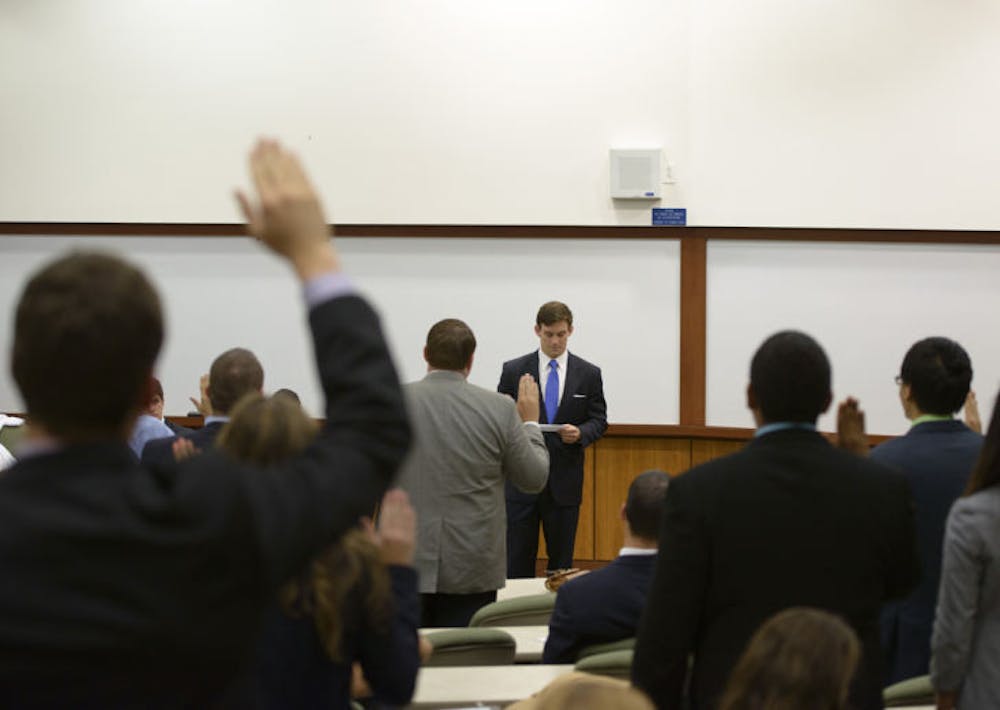 <p>UF Supreme Court Chief Justice Marcus Powers swears in newly elected senators at Tuesday’s double-header Senate meeting. The Fall 2013 elections results were ratified prior to the second meeting.</p>