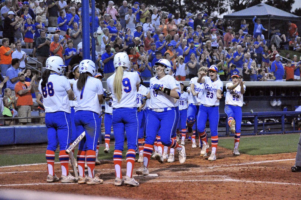 UF players meet senior Lauren Haeger at home plate following Haeger's home run during Florida's 10-2 win against South Carolina on Friday at Katie Seashole Pressly Stadium.