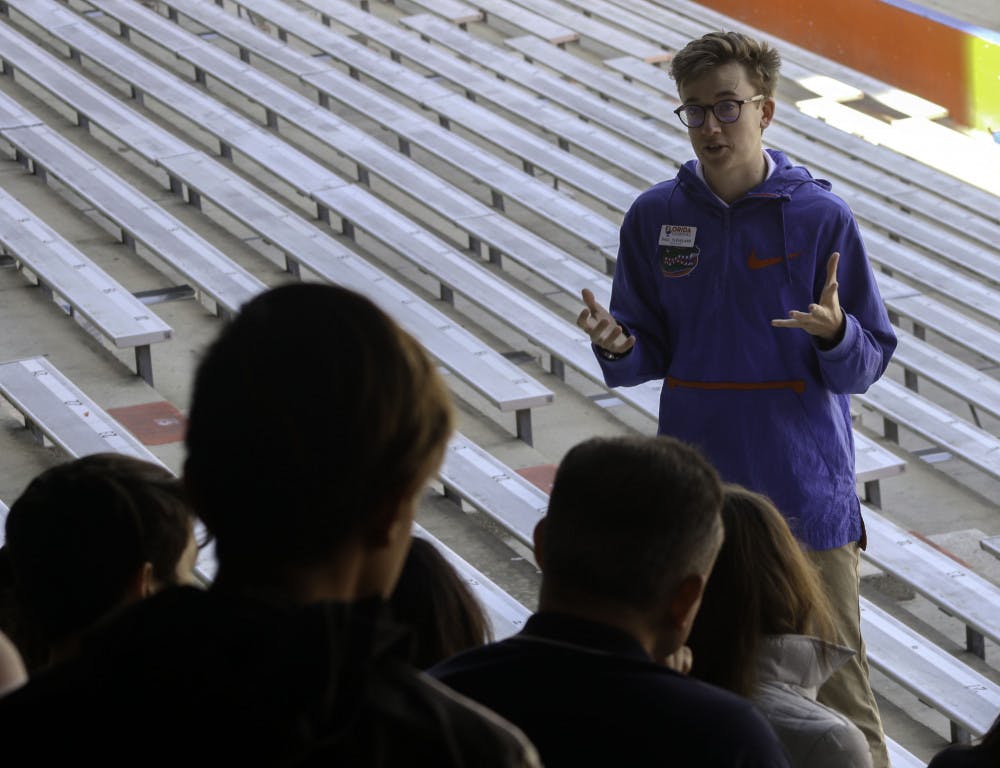Paul Cleveland, a 20-year-old UF economics junior and Cicerone, talks to a tour group in The Swamp about the football program at the school on Friday. Chris Day / Alligator Staff