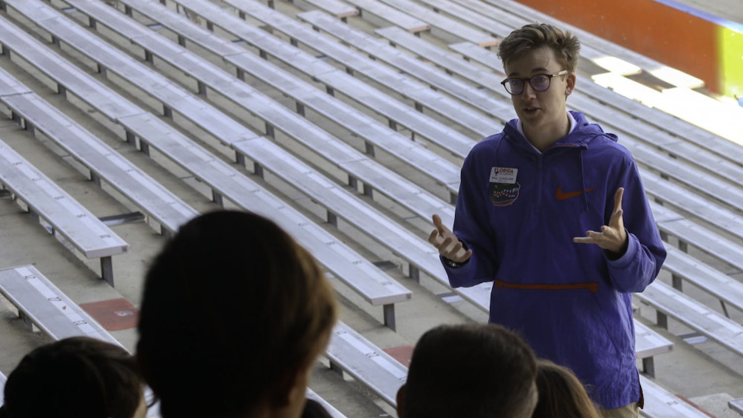 Paul Cleveland, a 20-year-old UF economics junior and Cicerone, talks to a tour group in The Swamp about the football program at the school on Friday. Chris Day / Alligator Staff