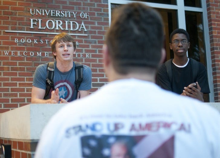 Matthew Tayon, 20, a junior biochemistry major, debates with a protester outside the UF bookstore on Thursday evening.