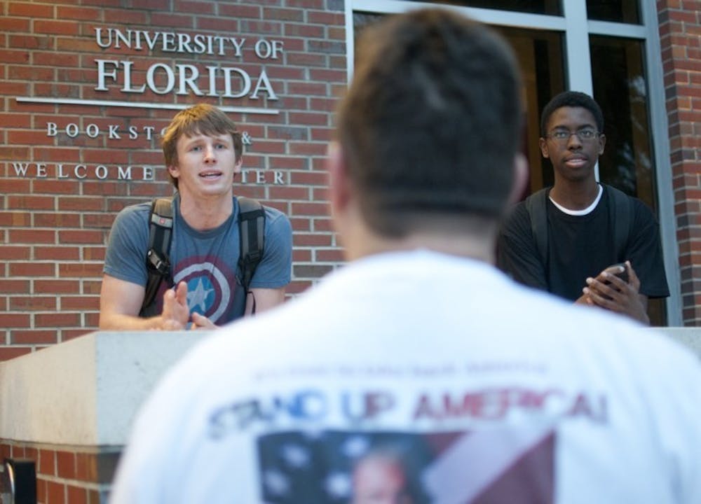 <p>Matthew Tayon, 20, a junior biochemistry major, debates with a protester outside the UF bookstore on Thursday evening.</p>