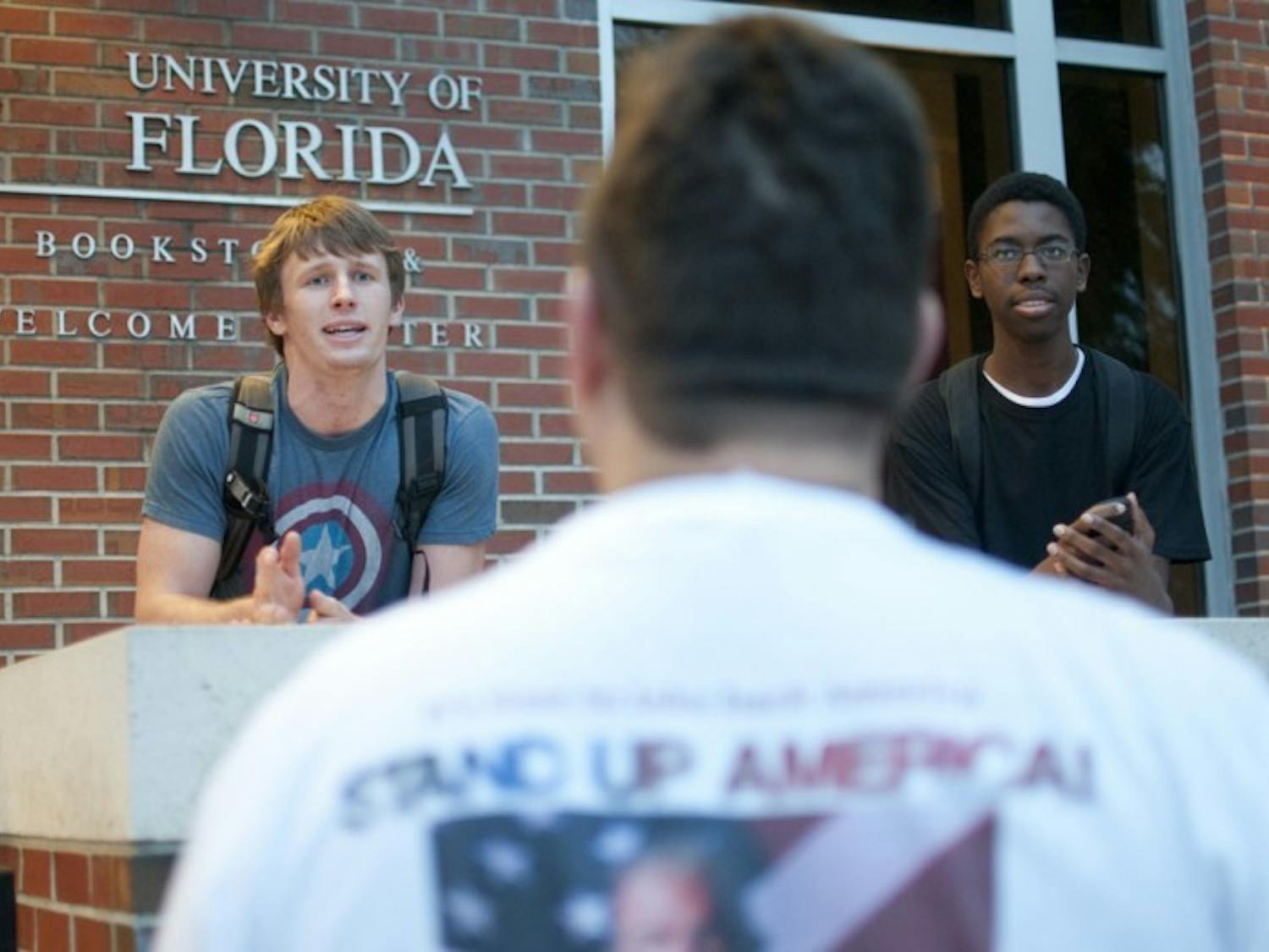 Matthew Tayon, 20, a junior biochemistry major, debates with a protester outside the UF bookstore on Thursday evening.