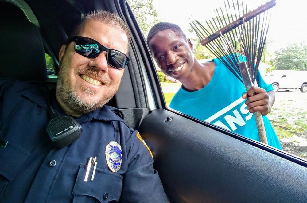 Gainesville Police officer Bobby White, also known as “Basketball Cop,” and 16-year-old entrepreneur James Edwards pose for a selfie Oct. 6 in Highland Court Manor neighborhood. The selfie went viral after White posted it to his Basketball Cop Foundation Facebook page, and White has since been dedicated to helping Edwards launch his own lawn-care business.