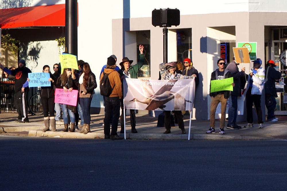 <p>Supporters gather at the intersection of University Avenue and Main Street on Saturday afternoon to protest recently proposed legislation that would allow logging, hunting and cattle grazing at Paynes Prairie Preserve State Park. The Paynes Prairie Coalition organized the rally, which marched one mile from First Magnitude Brewing Company to the downtown intersection.</p>