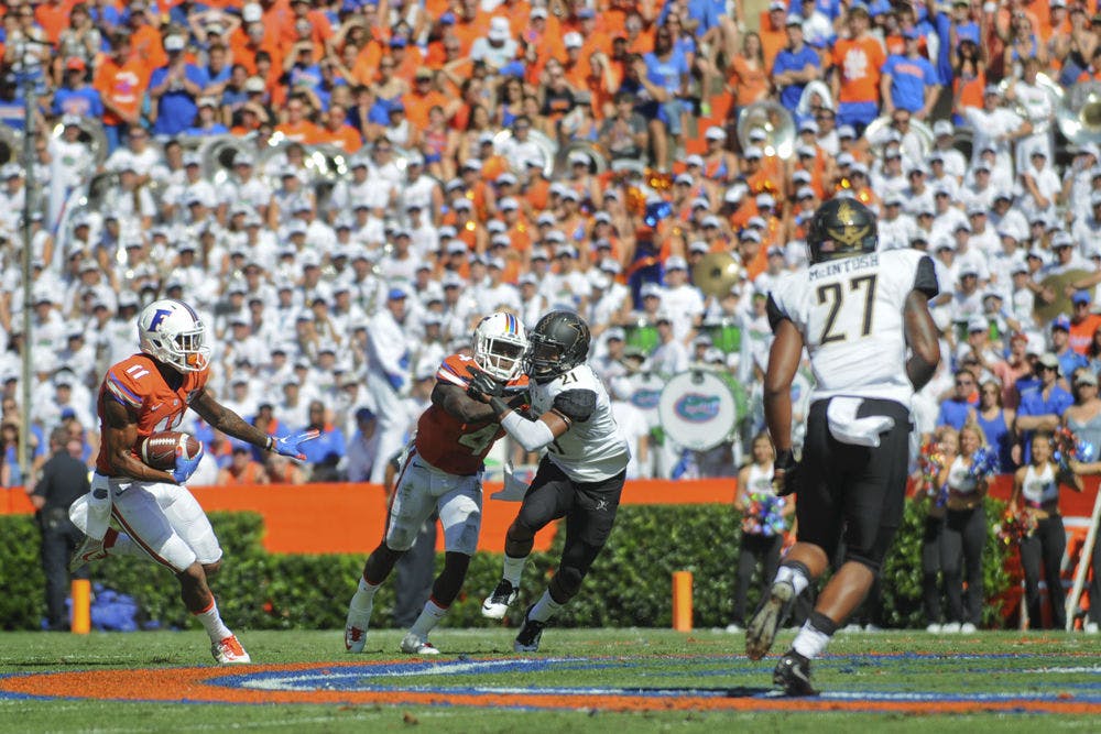 <p>UF's Demarcus Robinson (left) eludes defenders after catching a pass during Florida's 9-7 win against Vanderbilt on Nov. 7, 2015, at Ben Hill Griffin Stadium.</p>