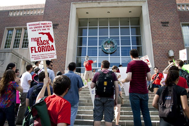 People protest in front of Tigert Hall on Wednesday afternoon as part of a protest organized by Graduate Assistants United against increasing student fees.