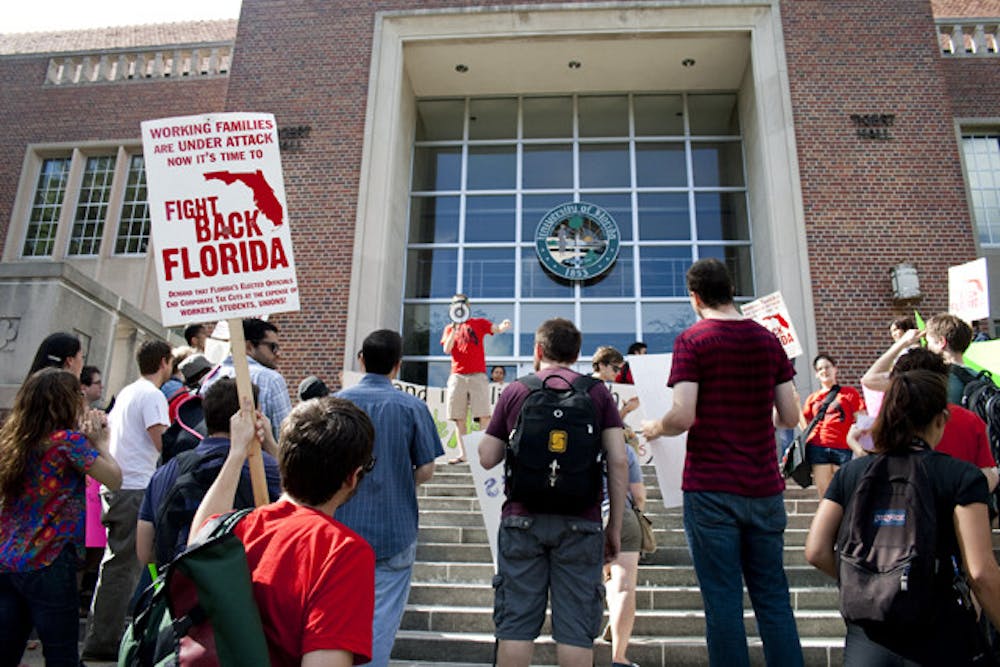 <p>People protest in front of Tigert Hall on Wednesday afternoon as part of a protest organized by Graduate Assistants United against increasing student fees.</p>