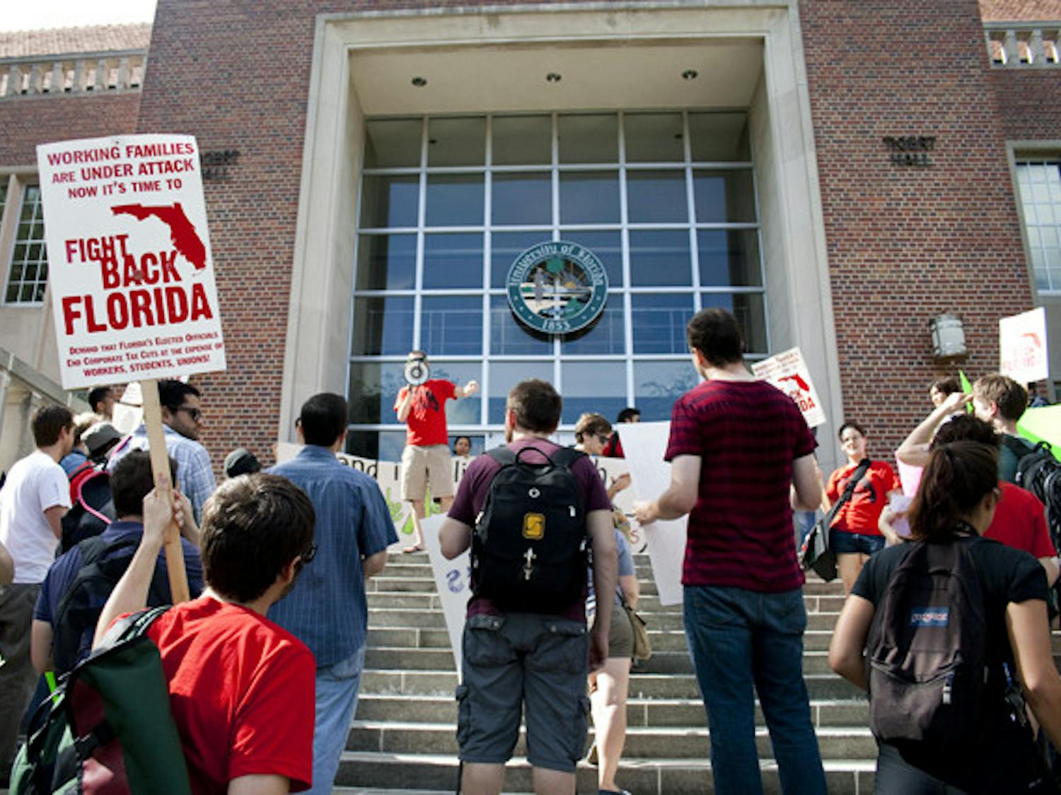 People protest in front of Tigert Hall on Wednesday afternoon as part of a protest organized by Graduate Assistants United against increasing student fees.