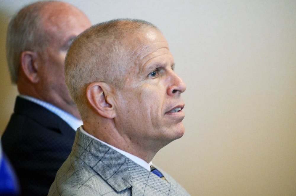 UF athletics director Jeremy Foley listens as Jim McElwain gives his press conference on Dec. 6, 2014, at Ben Hill Griffin Stadium.