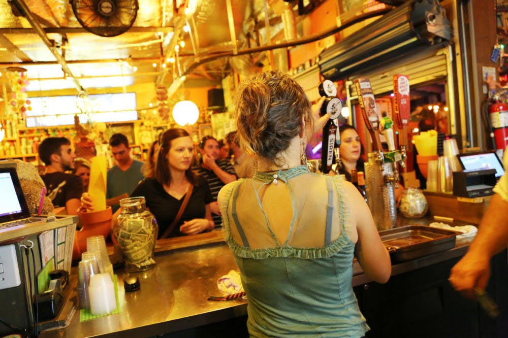 Bartender Brieann Milata, 25, serves thirsty patrons at the First Magnitude Brewing Company launch party at Satchel’s Pizza on Wednesday.