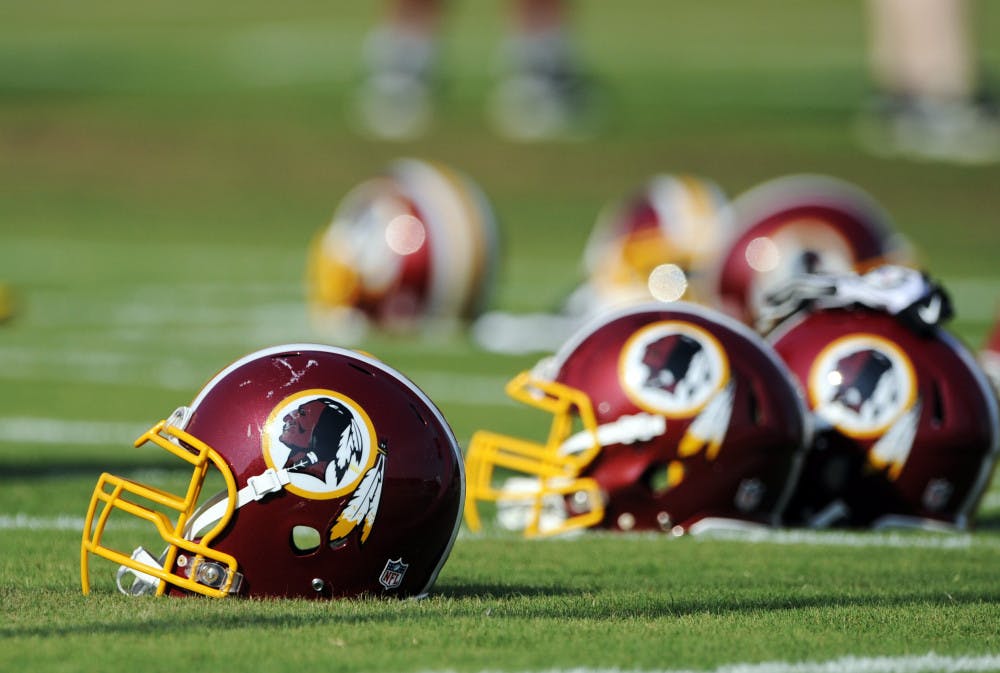 Washington Redskins helmets sit on the field during NFL football minicamp. The U.S. Patent Office ruled Wednesday that the Washington Redskins nickname is “disparaging of Native Americans.”