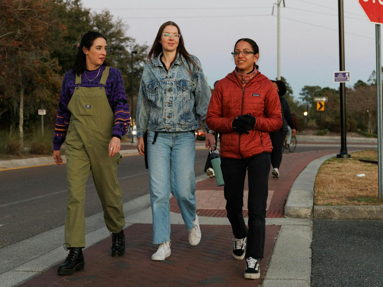 Hollyn Belhart, Christy Lynch and Natalia Medina walk on trail during a City Girls Who Walk Gainesville meet in Gainesville, Fla., Wednesday, Jan. 28, 2026.