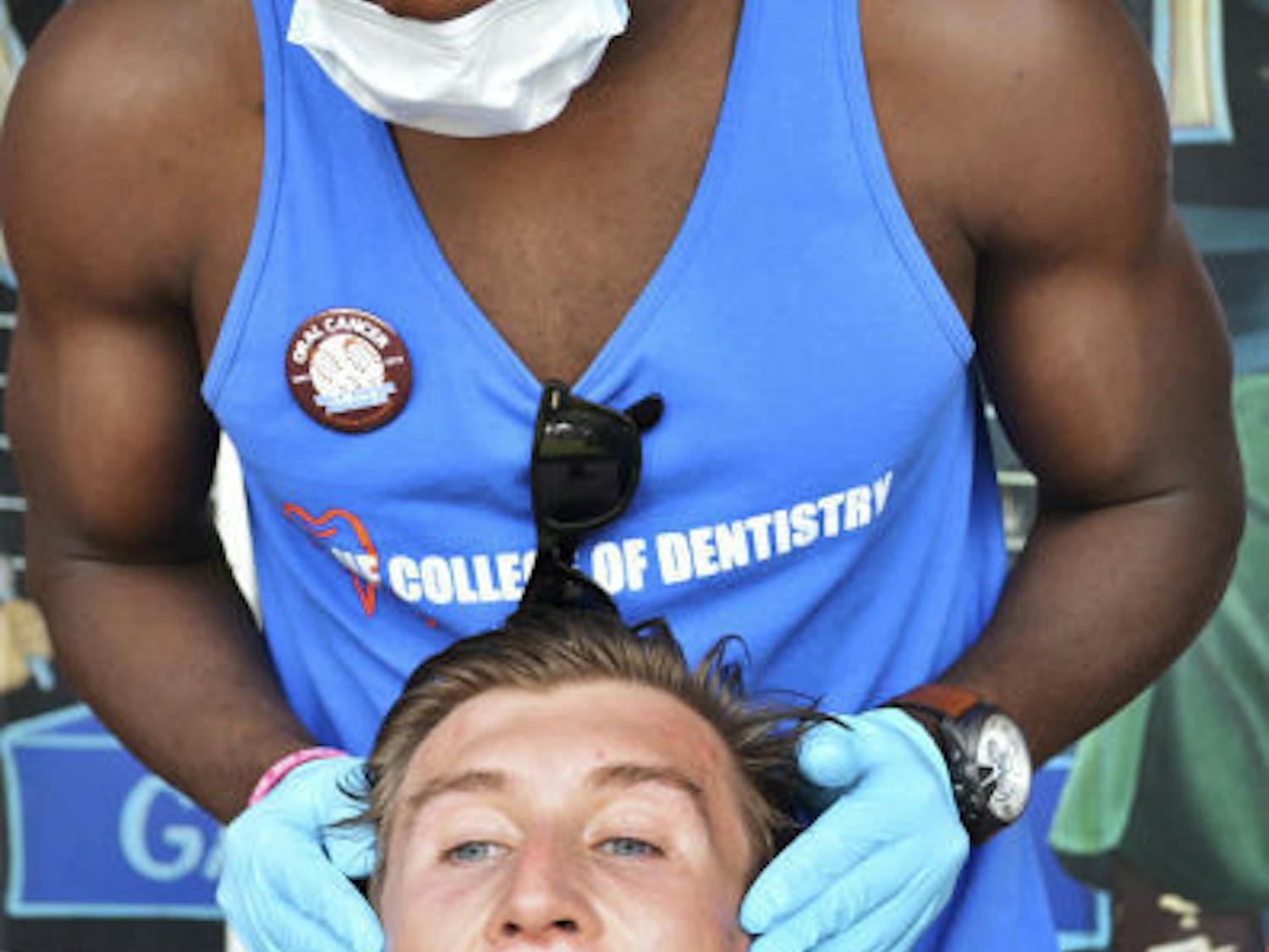 Patrick Lolo, a senior UF dental student, checks the mouth of Derek Bolser, a junior UF natural resource conservation major, during the 2nd Annual Oral Cancer Foundation 5K Run/Walk for Awareness on Bo Diddly Plaza on Saturday.