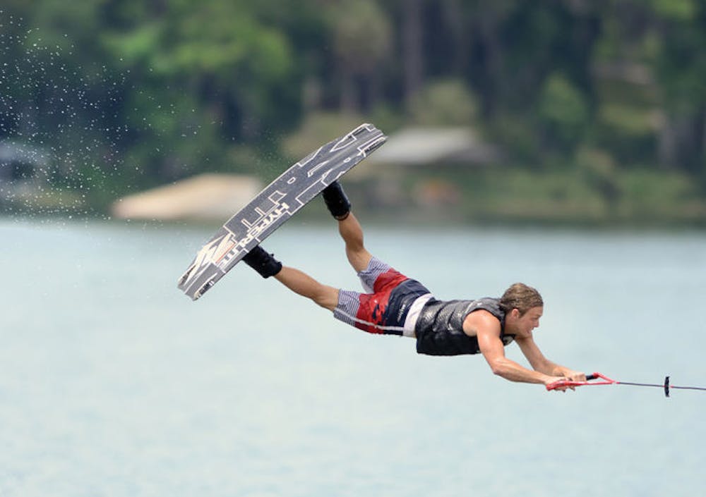 <p>James Ort, 21, extends his body during a trick at Wakefest 2013. About 15 students performed in several categories of wakeboarding at Lake Wauburg.</p>