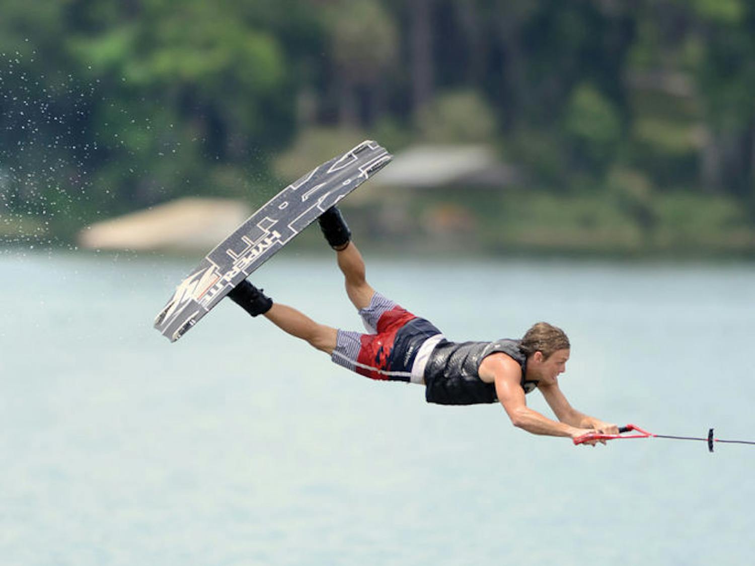 James Ort, 21, extends his body during a trick at Wakefest 2013. About 15 students performed in several categories of wakeboarding at Lake Wauburg.