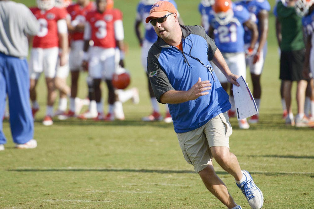<p>Florida offensive coordinator Kurt Roper scans the field during practice on Aug. 14 at Donald R. Dizney Stadium.</p>