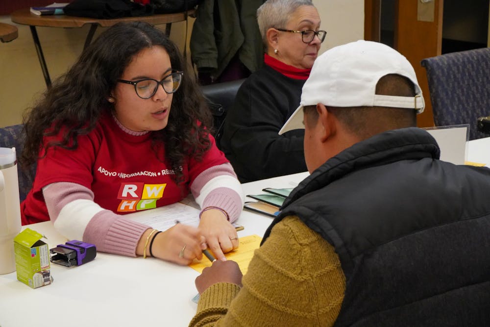 <p>RWHP volunteer helps man fill out his notary paperwork.</p>