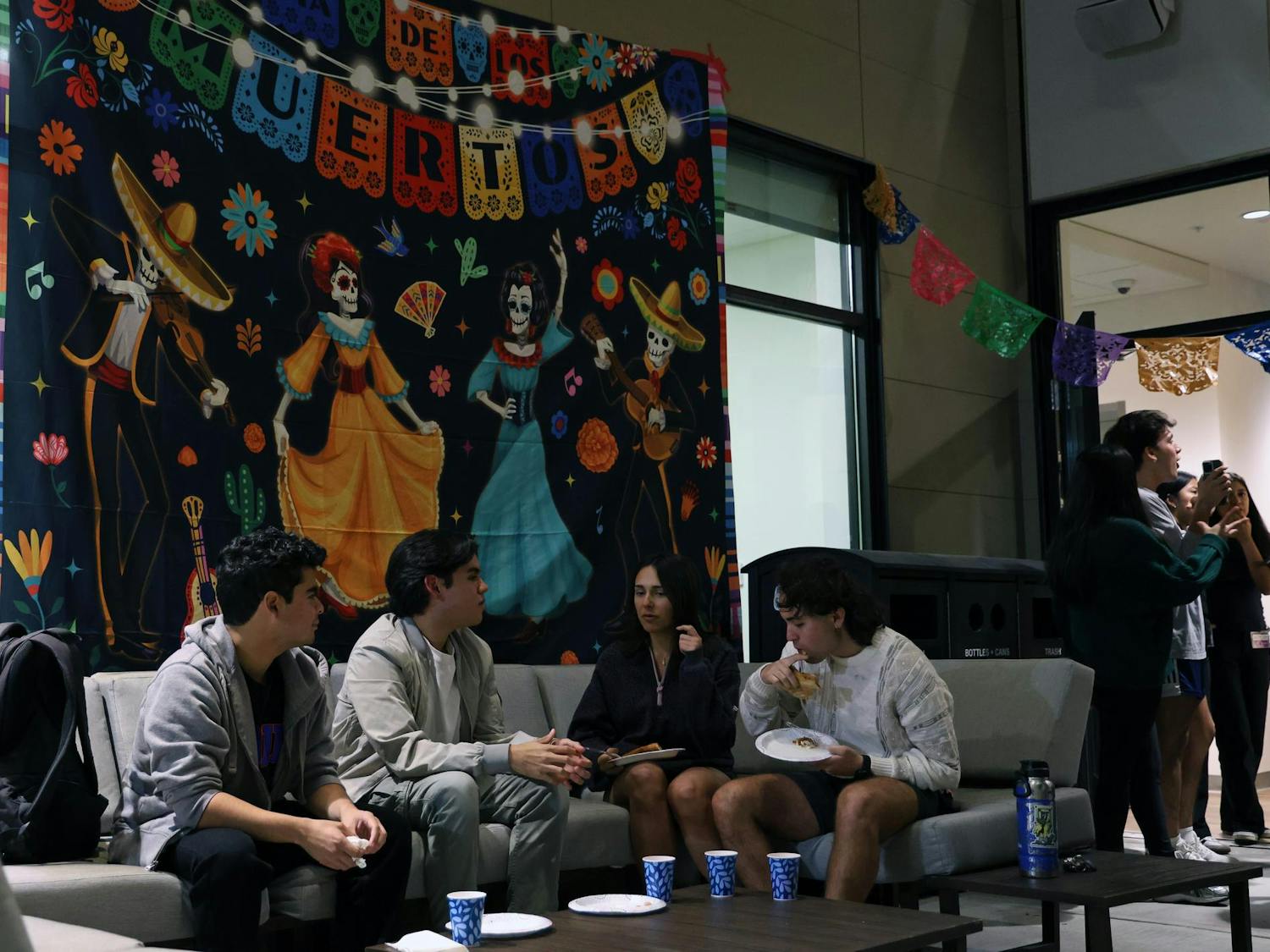Attendees sit in the courtyard of the Institute of Hispanic-Latino Cultures during the Mexican American Student Association’s Día de los Muertos celebration on Monday, Nov. 3, 2025.