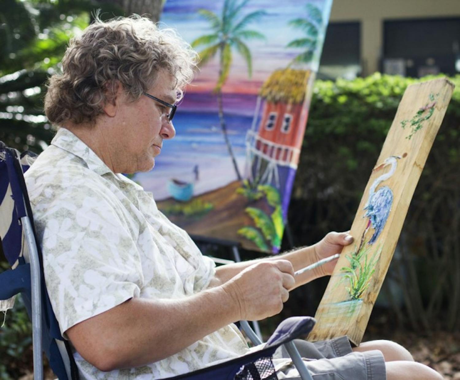 Dennis Shattuck, a 58-year-old painter from Palm Bay, touches up his 3-D crane painting at the Gainesville Fine Arts Association's 28th annual GFAA Art Festival at Thornebrook over the weekend.