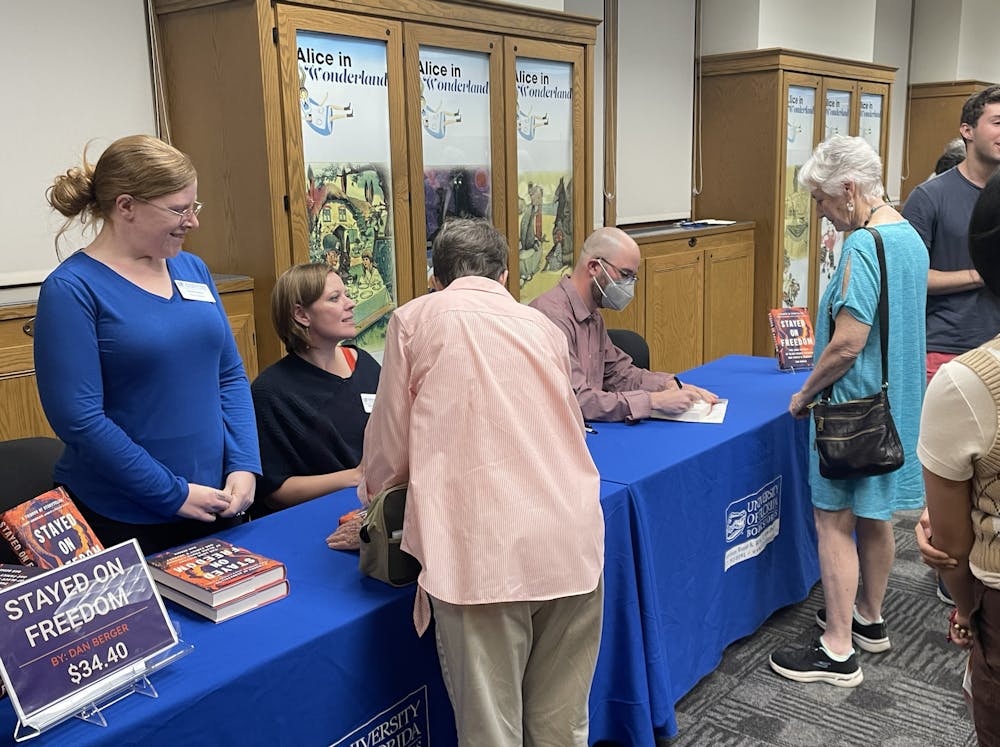 Dr. Dan Berger, a UF alum and author, signs his books and talks with attendees at a UF Samuel Proctor Oral History Program event on Thursday, Feb. 23, 2023.