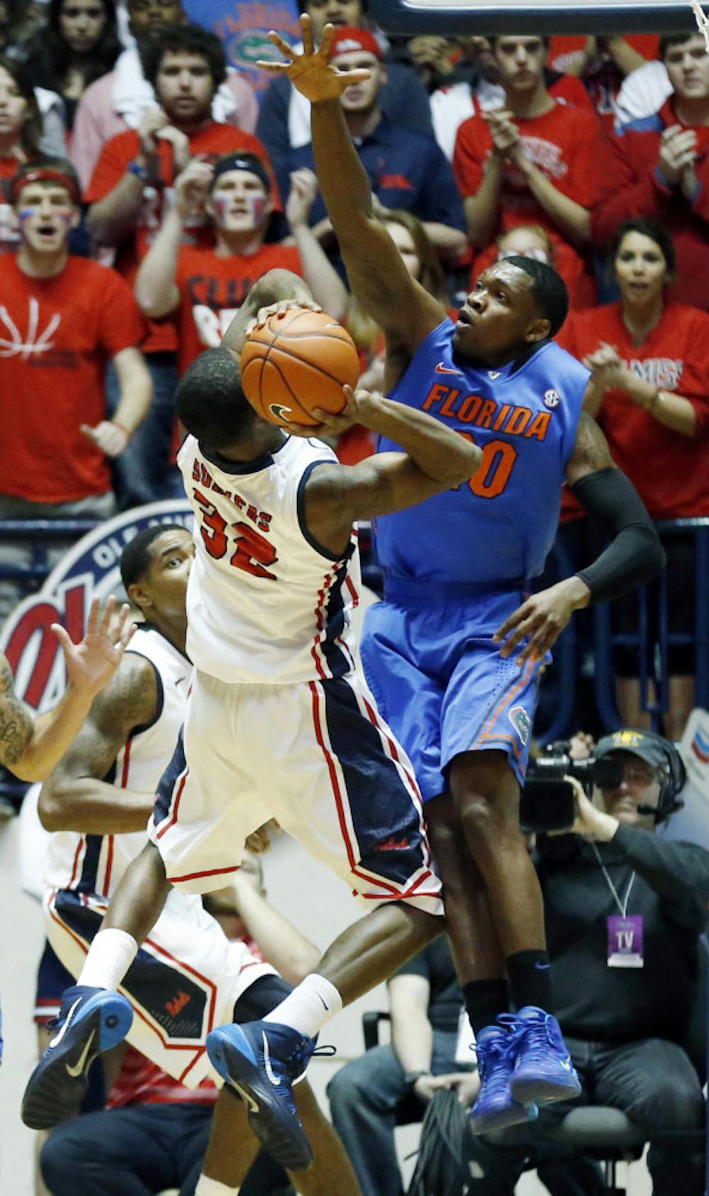 <p>Michael Frazier II (20) reaches up to block a shot by Ole Miss guard Jarvis Summers (32) during the Gators’ win over the Rebels on Saturday.</p>