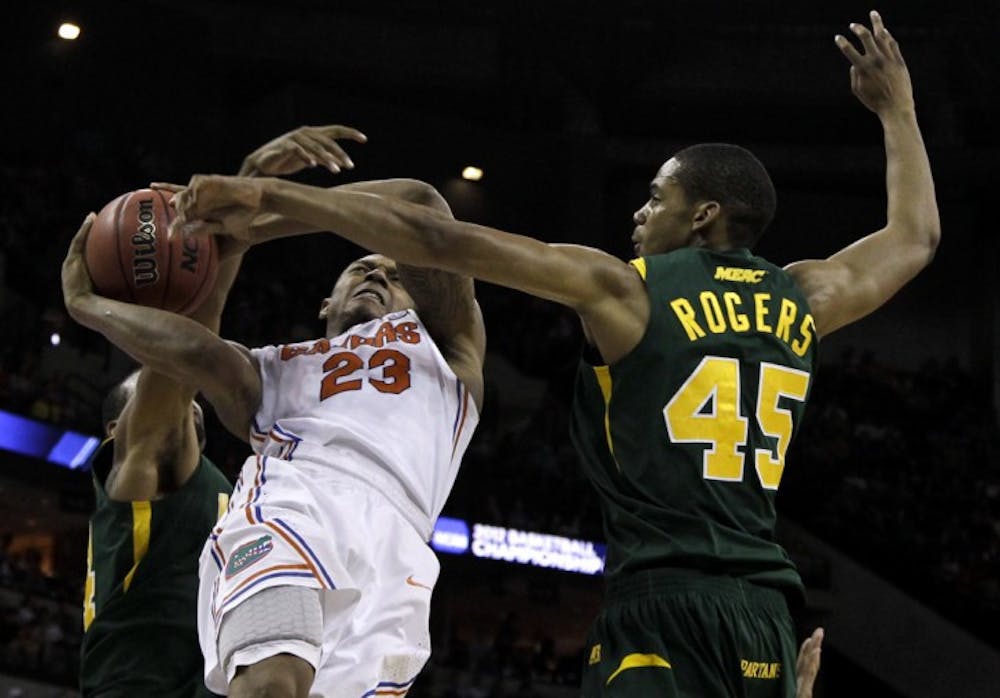 <p>Freshman guard Brad Beal (23) gets tangled up with Norfolk State forward A.J. Rogers and guard Brandon Wheeless while driving to the basket in UF’s third-round win Sunday.</p>