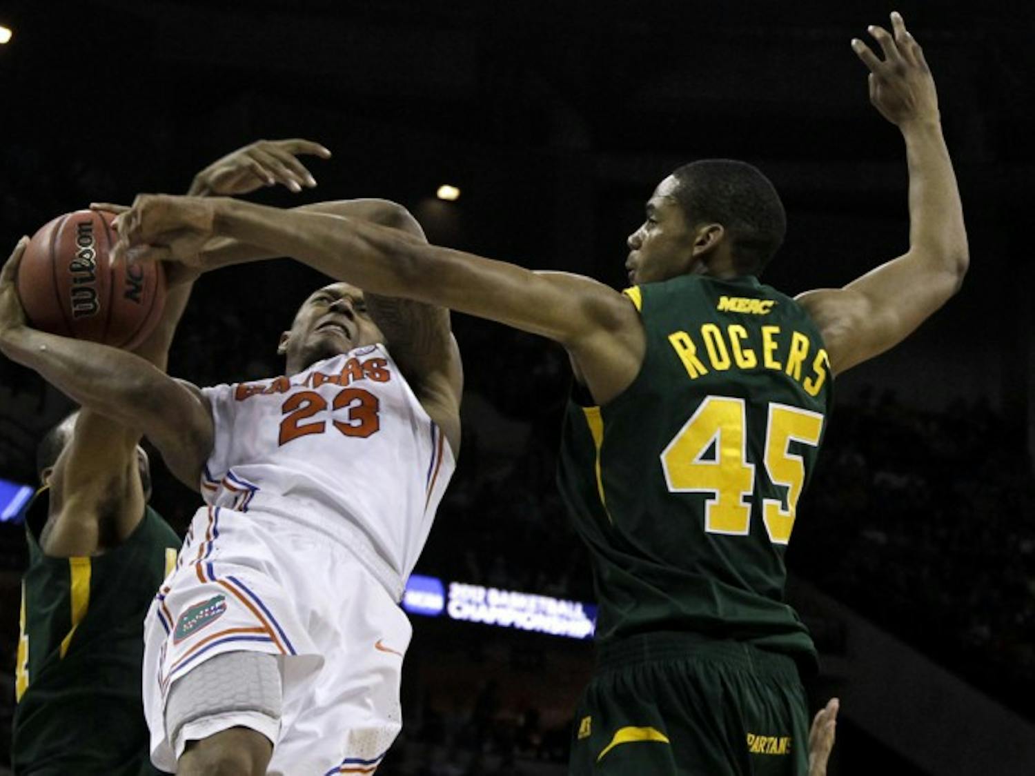 Freshman guard Brad Beal (23) gets tangled up with Norfolk State forward A.J. Rogers and guard Brandon Wheeless while driving to the basket in UF’s third-round win Sunday.
