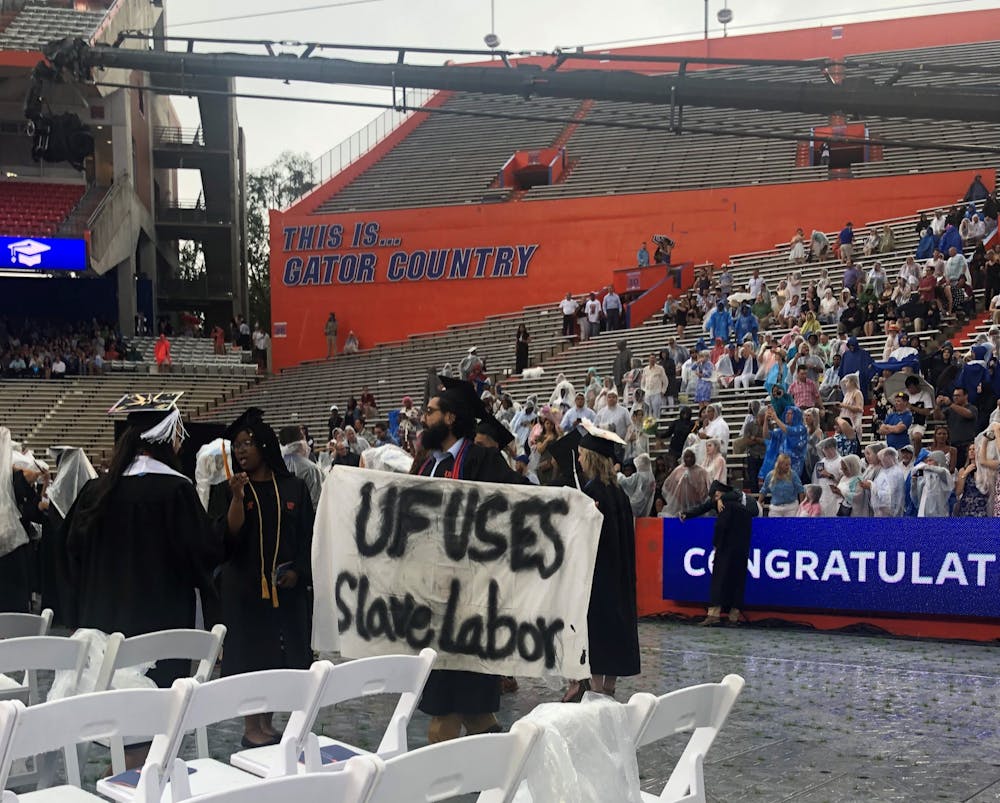 <p>Syed Muhammad Omar holds a banner during the College of Liberal Arts and Sciences commencement ceremony on Sunday. Omar, a 27-year-old UF psychology bachelor’s graduate, said he is involved with Divest UF.</p>