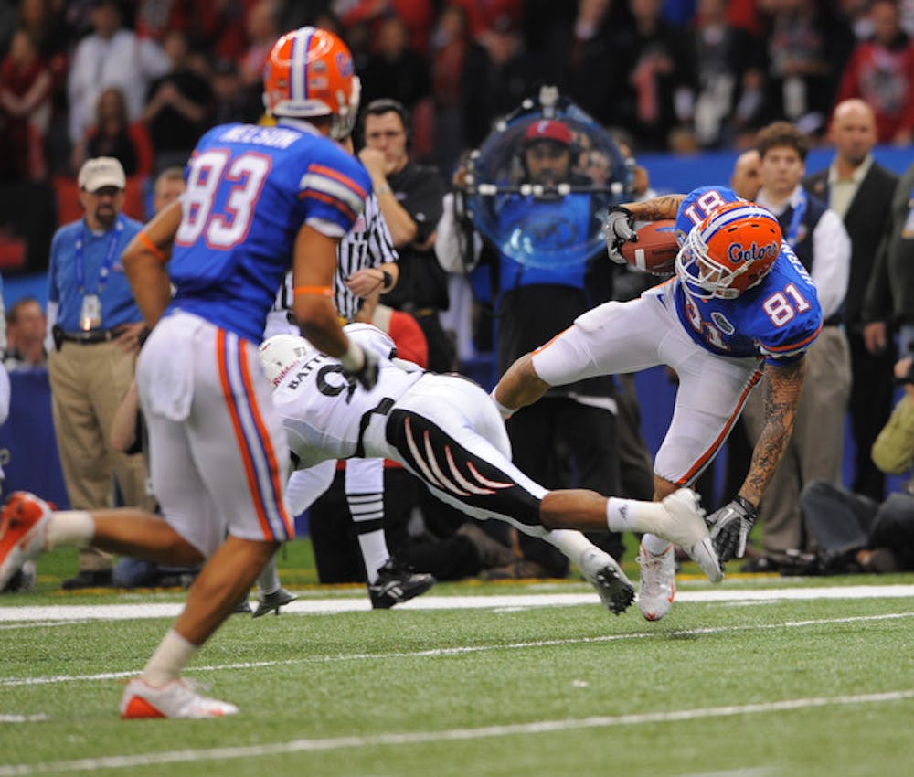 <p>Aaron Hernandez attempts to avoid a tackle in the Allstate Sugar Bowl on Jan. 1, 2010. Hernandez is in jail in relation to six charges, including the murder of Odin Lloyd.</p>
