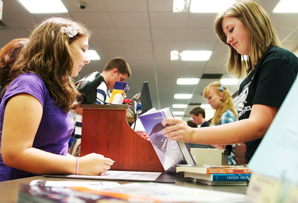 <p>UF freshman Christina Lynch, left, purchases a textbook at the UF Bookstore inside the Reitz Union on Thursday, Aug. 22, 2011.&nbsp;</p>