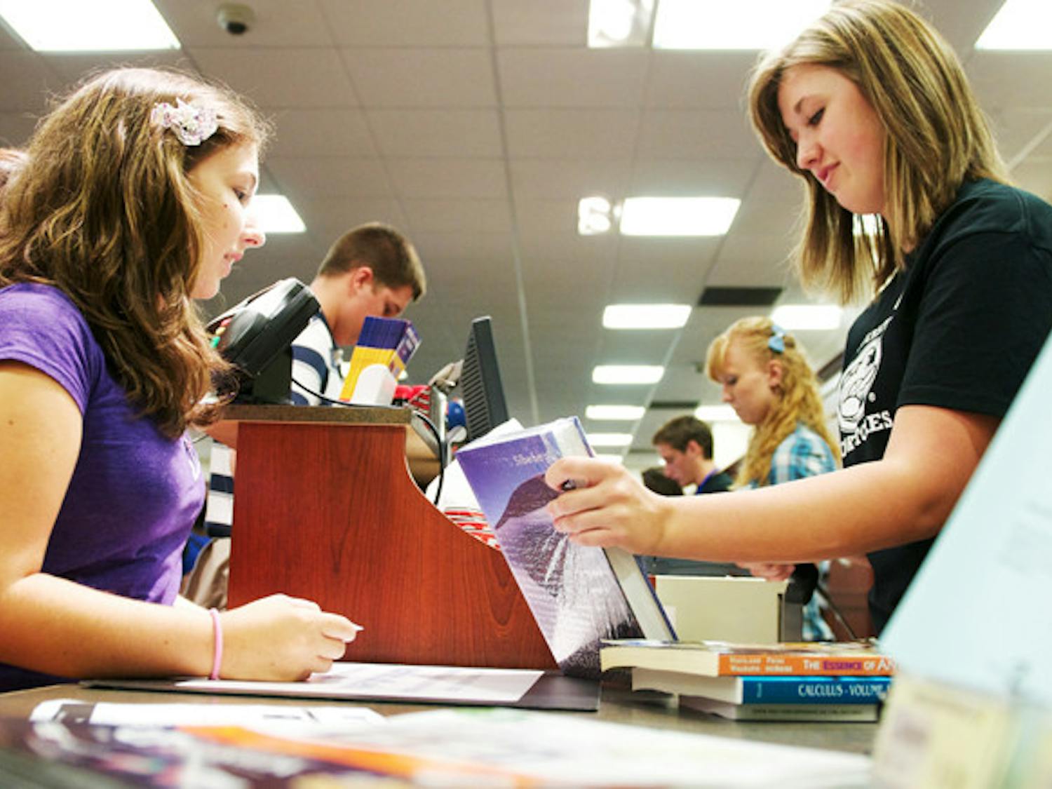 UF freshman Christina Lynch, left, purchases a textbook at the UF Bookstore inside the Reitz Union on Thursday, Aug. 22, 2011. 