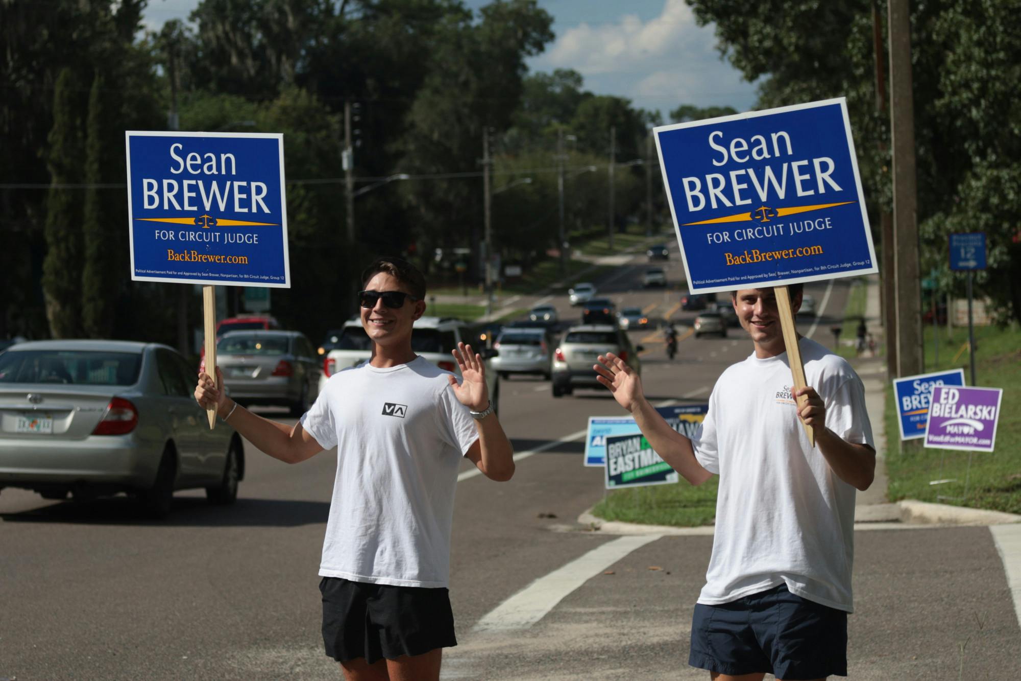Two individuals hold up signs for Circuit Judge Sean Brewer Tuesday, Aug. 24, 2022. 