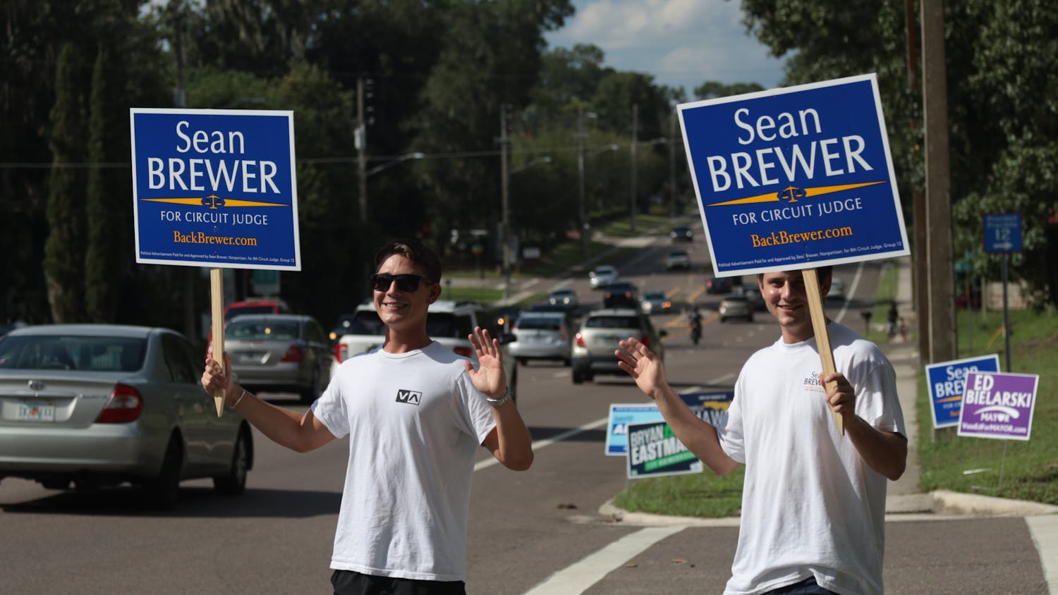 Two individuals hold up signs for Circuit Judge Sean Brewer Tuesday, Aug. 24, 2022. 