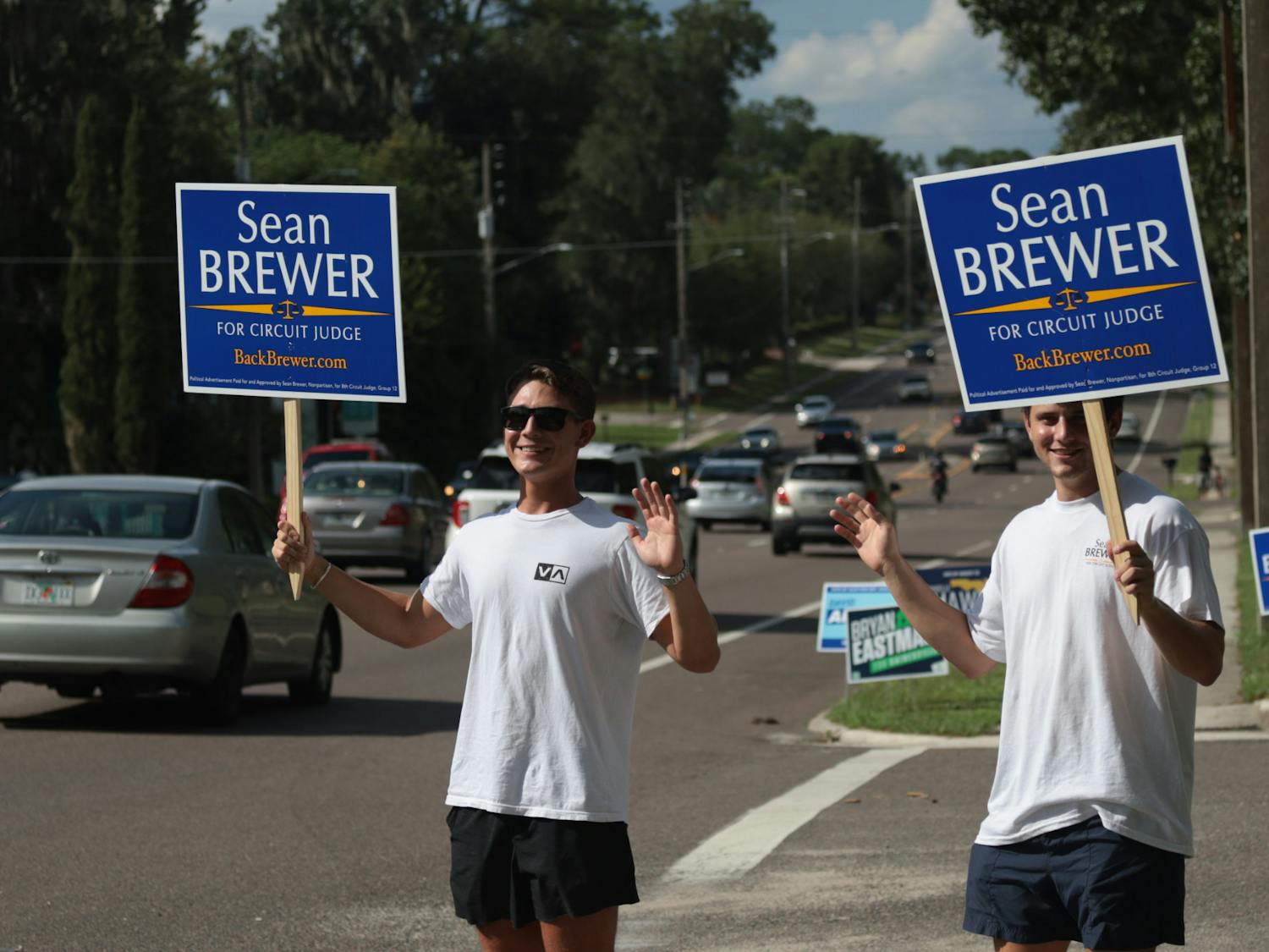 Two individuals hold up signs for Circuit Judge Sean Brewer Tuesday, Aug. 24, 2022. 