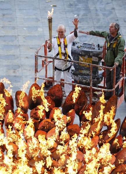 Torchbearer Austin Playfoot, top center, poses after lighting the Olympic cauldron at the Olympic Stadium during the 2012 Summer Olympics, Monday, July 30, 2012, in London. The cauldron was moved from the infield to its resting position at the stadium. (AP Photo/Jae C. Hong)