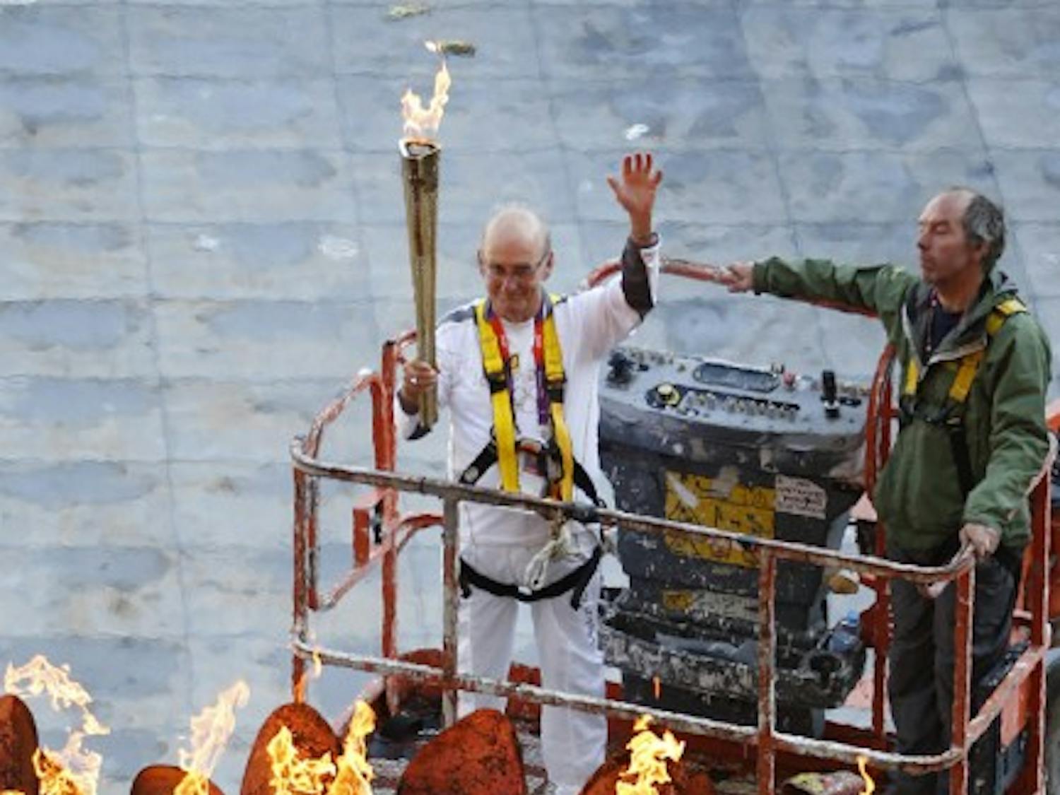 Torchbearer Austin Playfoot, top center, poses after lighting the Olympic cauldron at the Olympic Stadium during the 2012 Summer Olympics, Monday, July 30, 2012, in London. The cauldron was moved from the infield to its resting position at the stadium. (AP Photo/Jae C. Hong)
