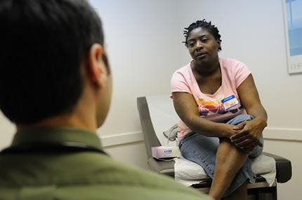 Adam Carter, a first year medical student, speaks with diabetes patient Katrina Thomas during the free medical clinic hours at the UF Family Practice Medical Group on Thursday.