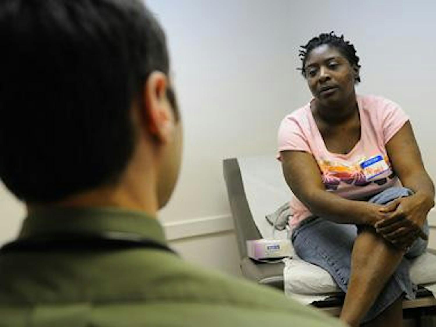 Adam Carter, a first year medical student, speaks with diabetes patient Katrina Thomas during the free medical clinic hours at the UF Family Practice Medical Group on Thursday.
