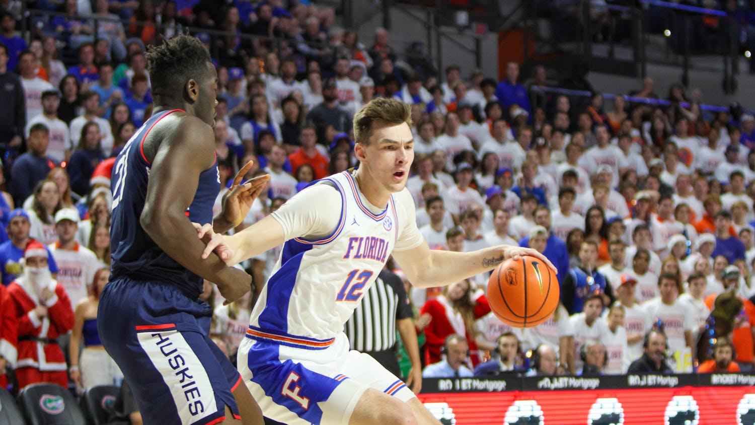 Fifth-year forward Colin Castleton drives past UConn forward Adama Sanogo during Florida&#x27;s loss to the No. 5 Huskies Wednesday, Dec. 7, 2022. 